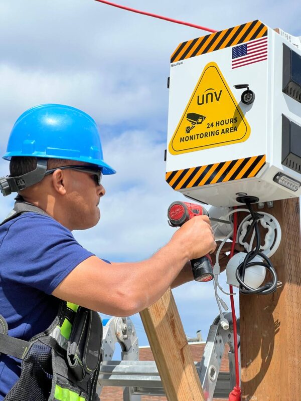Technician installing rental security camera monitoring unit