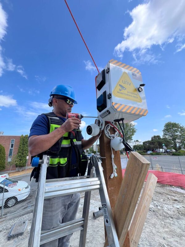 Technician mounting temporary surveillance camera unit
